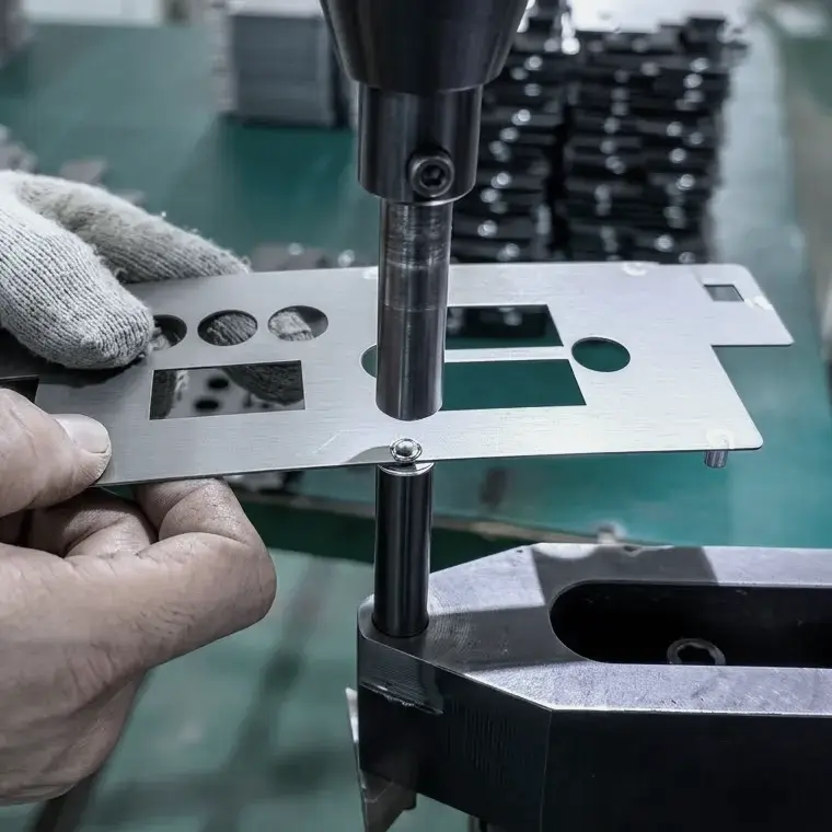 Pneumatic hardware insertion and self-clinching process installing threaded studs and nuts into laser-cut thin sheet metal.