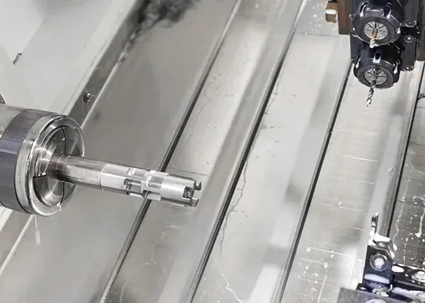 CNC turn-milling of a steel shaft with off-axis features using live tooling at FIWOK.